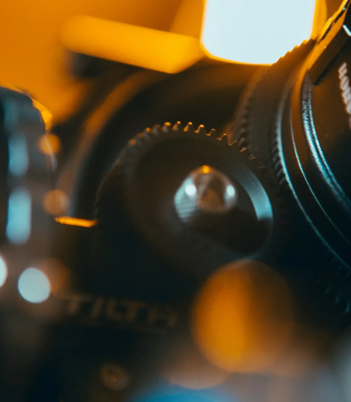 Camera lens in focus against a production backdrop